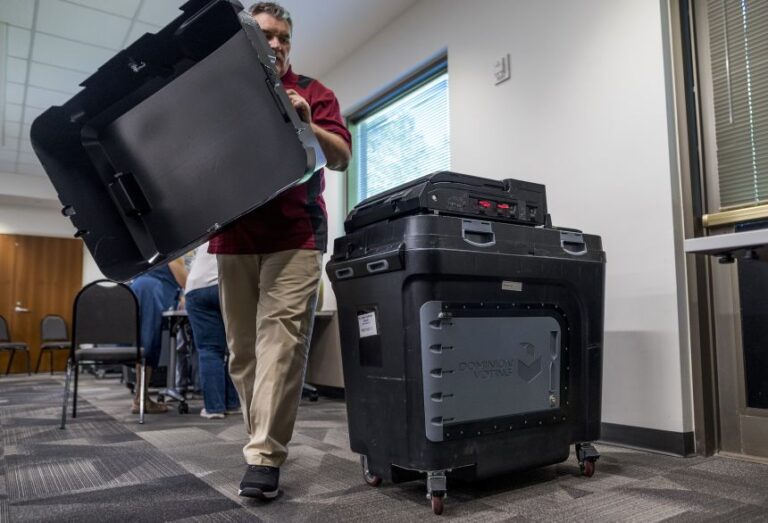 An election judge sets up a Dominion voting machine during a public accuracy test of voting equipment on August 3, 2022 in Burnsville, Minnesota.