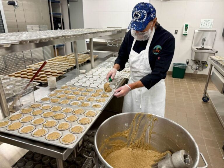 Tom Gullo, a sous chef at Littleton Public Schools Central Production Kitchen, scoops zucchini muffin batter into dozens of baking pans. Fresh-baked muffins are part of the school district's efforts to increase scratch-made items for student meals.