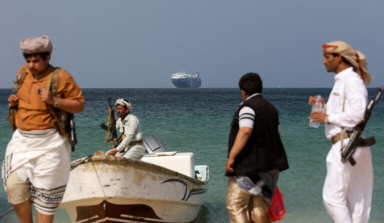 FILE PHOTO: Armed men stand on the beach as the Galaxy Leader commercial ship, seized by Yemen's Houthis last month, is anchored off the coast of al-Salif, Yemen, December 5, 2023. REUTERS/Khaled Abdullah/File Photo