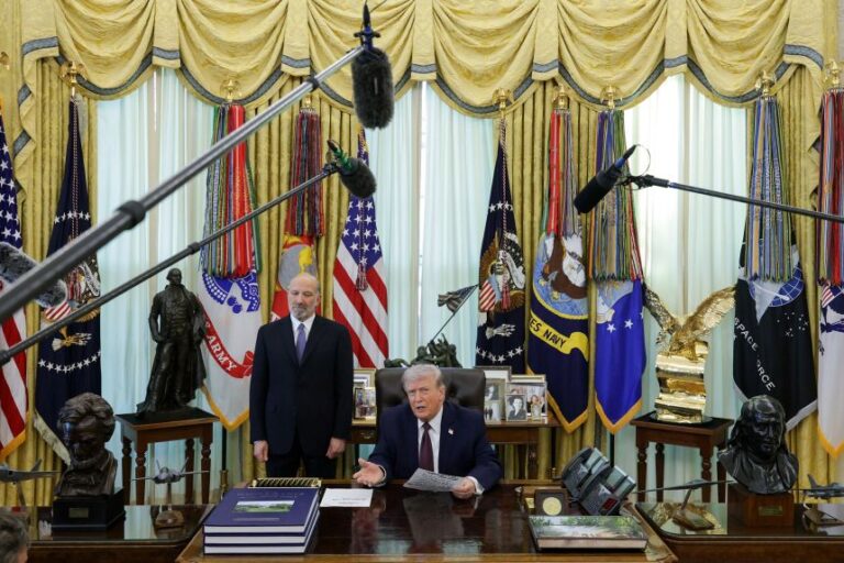 President Donald Trump speaks after signing an executive order attempting to limit mail-in voting, as Secretary of Commerce Howard Lutnick looks on, in the Oval Office of the White House on March 31, 2026.