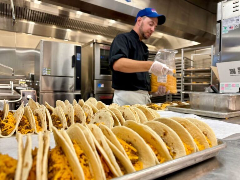Justin Weins, a member of the nutrition staff at Lenski Elementary School in Centennial, Colorado, prepares beef and cheese tacos before lunch service.