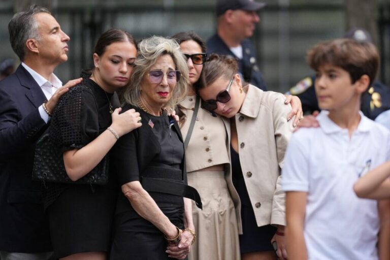 People listen to the national anthem at the memorial in New York.