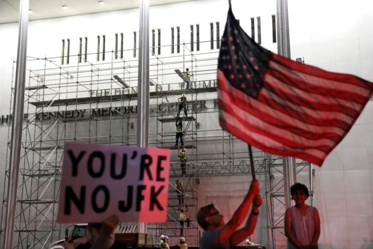 People wait for President Donald Trump's name to be removed from the John F. Kennedy Center for the Performing Arts in Washington, on June 12.