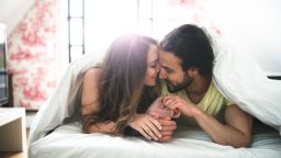 couple kissing on the bed on early morning