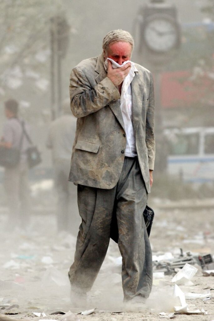 Edward Fine covers his mouth as he walks through debris in Manhattan on September 11, 2001.