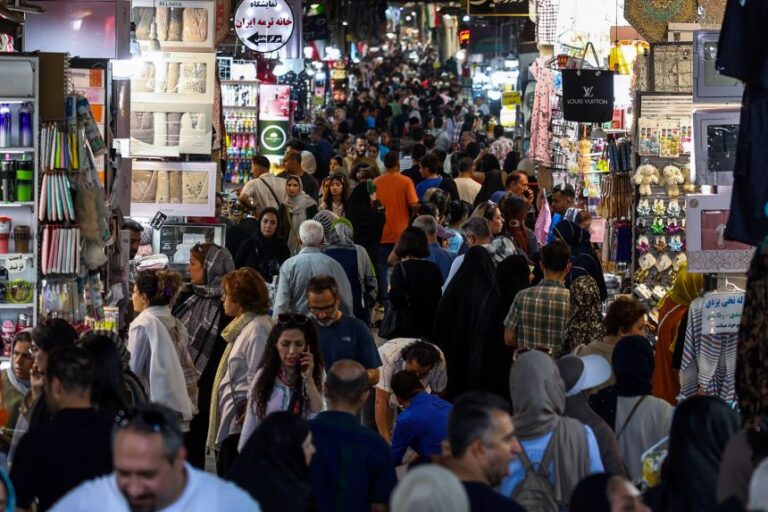 People walk past shops and browse for goods at the Grand Bazaar in Tehran on August 24. President Donald Trump billed his plan to isolate the Iranian economy as the