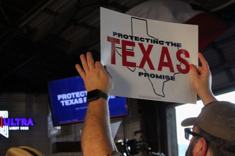 A crowd member waves a sign during Texas Attorney General Ken Paxton's rally for his US Senate campaign at Brewster Street Icehouse in Corpus Christi, Texas, on September 2.