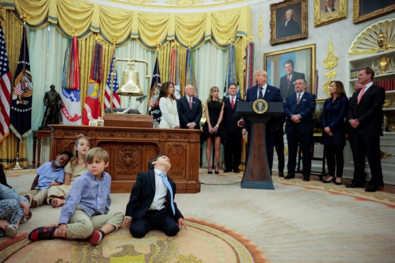 Children rest on the floor as President Donald Trump speaks during an event to mark the launch of