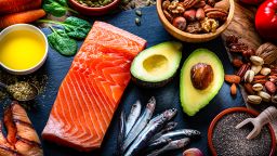 Healthy eating: high angle view of a group of food with high levels of Omega-3 fat. The composition includes salmon, sardines, avocado, extra virgin olive oil, and various nuts and seeds like pumpkin seeds, chis seeds, pecan, almonds, pistachio, walnuts and hazelnuts. High resolution 42Mp studio digital capture taken with Sony A7rII and Sony FE 90mm f2.8 macro G OSS lens