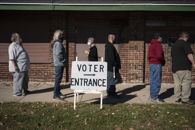 Voters wait in line outside a polling center on Election Day, in Kenosha, Wisconsin, on November 3, 2020.