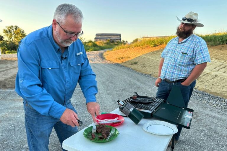Brent Williams, left, prepares ostrich meat with farm owner W.D. King.