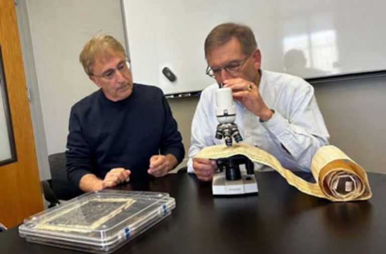 Physicist Karl van Bibber (right), professor at UC Berkeley, examines the ink on a replica scroll to confirm lead density calculations while Douglas Seiler, research volunteer at UC Berkeley, looks on.