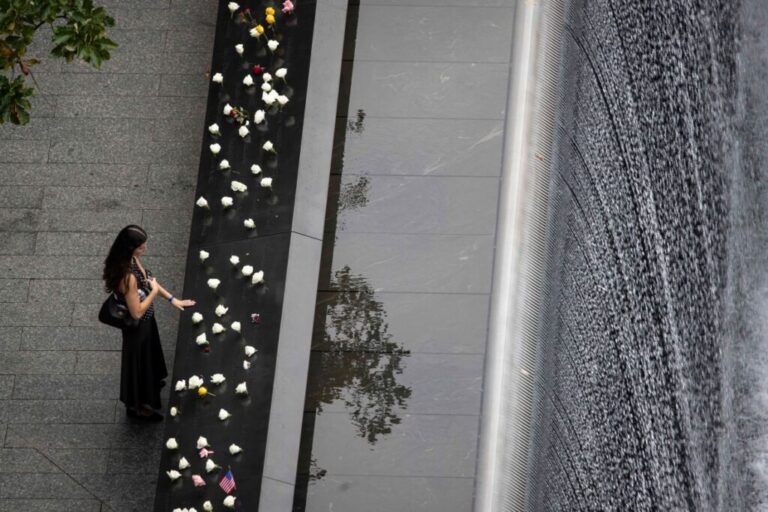 A woman mourns at the reflecting pool in New York.