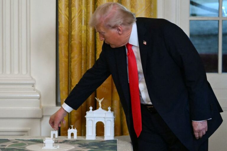 President Donald Trump stands near models for a proposed