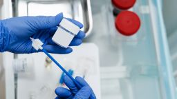 Gynecologist is holding flask for cytology Pap smear test in hands. Gynecological cytology Pap smear test and cytobrush in hands of gynecologist