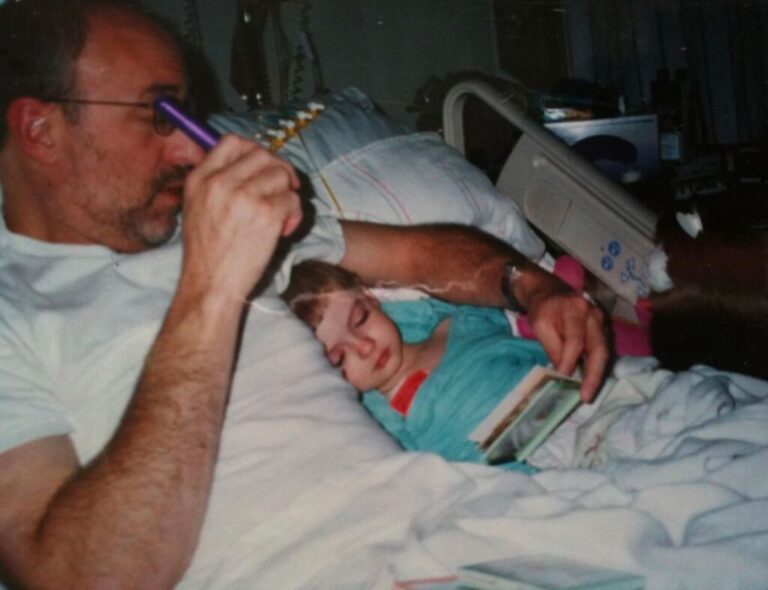 Olivia's father reads to her during an early hospital stay.