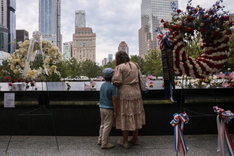A woman and child pay respects at the 9/11 Memorial and Museum during a ceremony on Friday, September 11, commemorating the 25th anniversary of the terror attacks on the World Trade Center in New York.