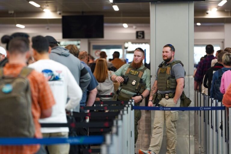 ICE agents stand next to the security line at Atlanta Hartsfield-Jackson International Airport in Atlanta, on March 23.