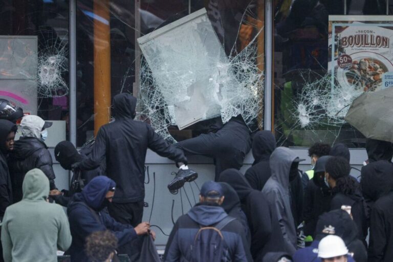 Protesters break windows of a French food store during a demonstration in Paris on Saturday.
