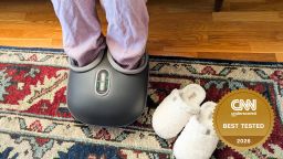 Woman using an electric foot massager in her living room