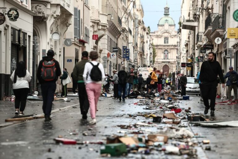Pedestrians walk along a street covered in debris in Marseille on Sunday.