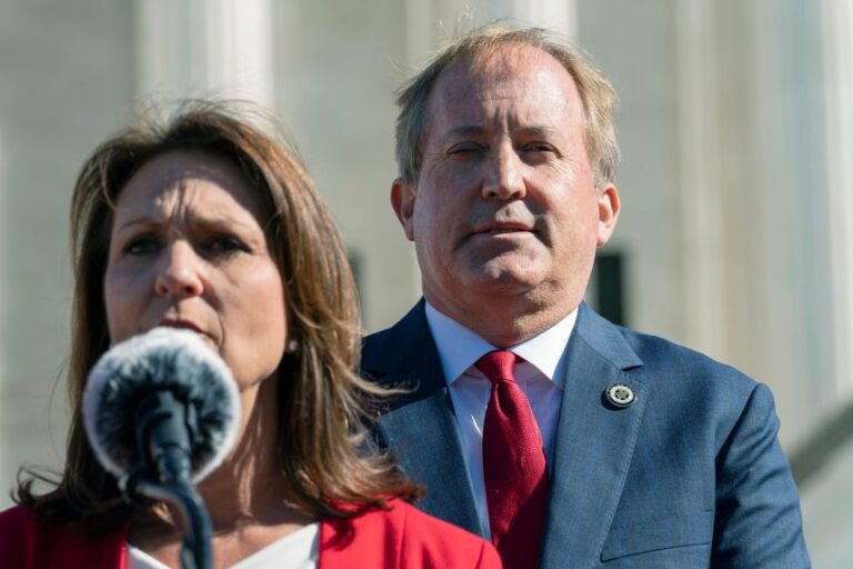 Texas Attorney General Ken Paxton, right, listens as his estranged wife, Texas State Sen. Angela Paxton, speak to anti-abortion activists at a rally outside the Supreme Court, on Nov. 1, 2021.