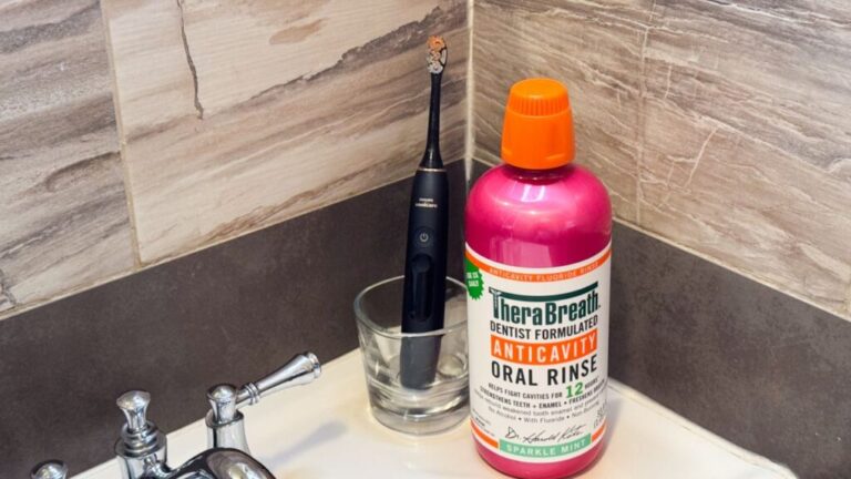 TheraBreath Anticavity Fluoride Oral Rinse next to toothbrush.