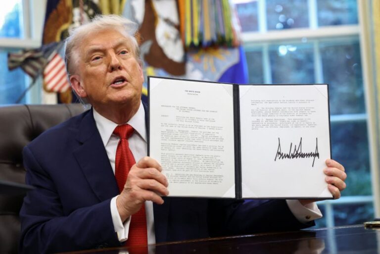President Donald Trump shows a signed memorandum on the implementation of the death penalty in Washington, DC, at the White House on September 25, 2025.
