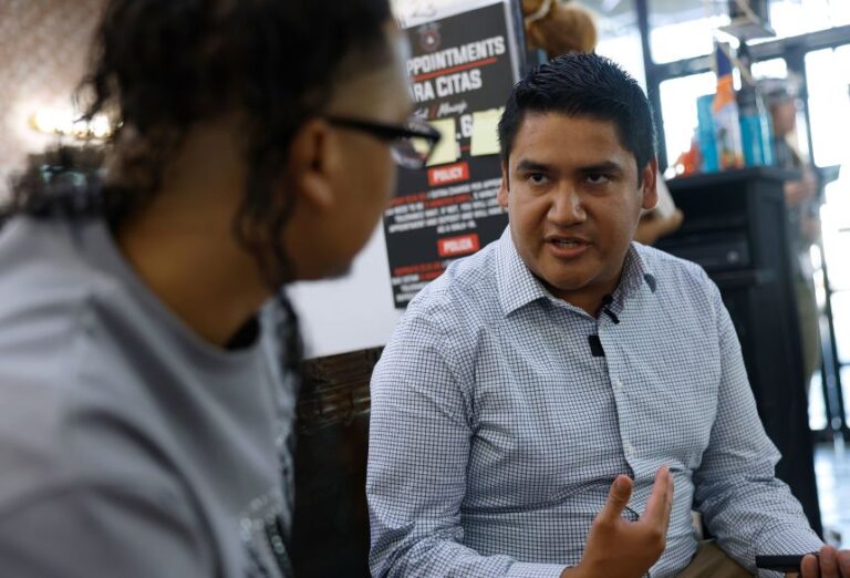 Democratic candidate Randy Villegas talks with a customer at Aztecas Barber Shop in Bakersfield, California, on September 17.