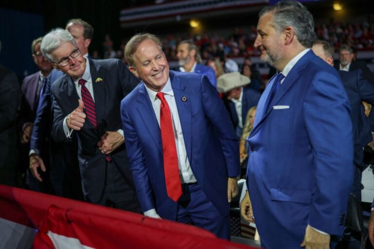 Texas Attorney General Ken Paxton, center, smiles a campaign rally with President Donald Trump in San Antonio on October 7.