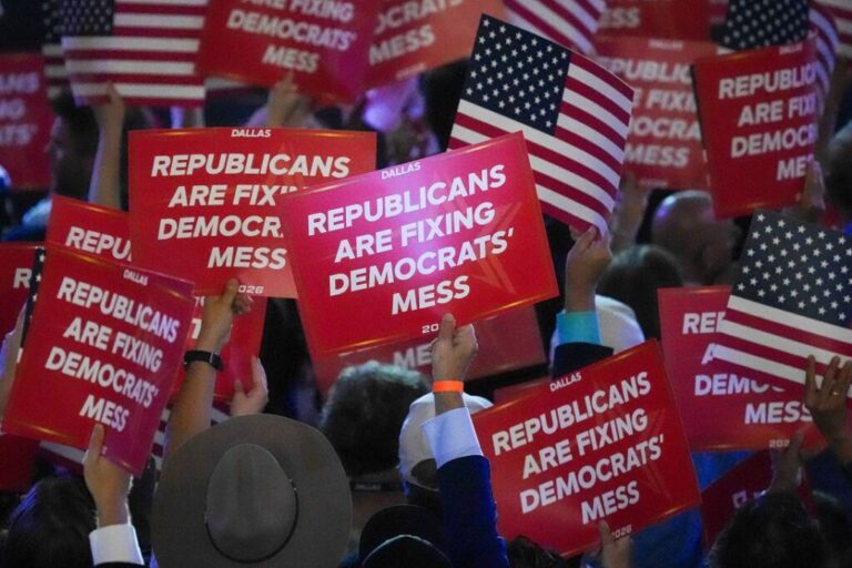 Attendees hold signs reading