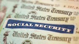 A photo illustration shows a Social Security card alongside checks from the US Treasury on October 14, 2021 in Washington, DC.