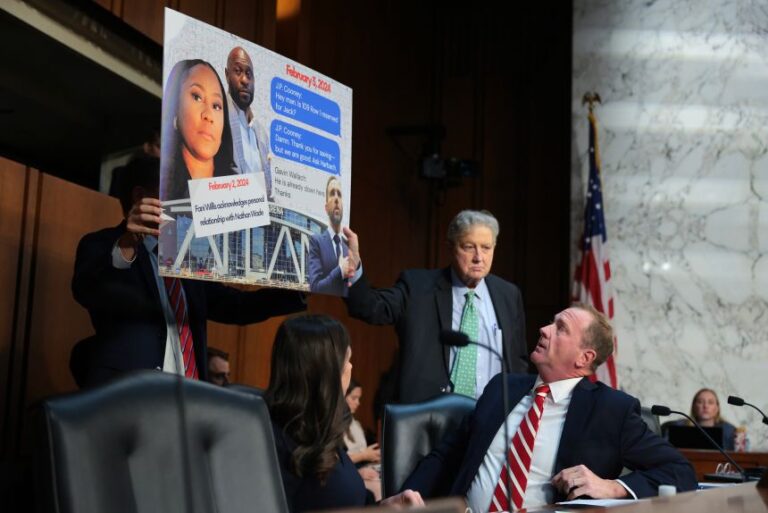 Sen. Eric Schmitt gestures to a sign accusing former Special Counsel Jack Smith of meeting with Fani Willis, the district attorney for Fulton County, Georgia, during a hearing before the Senate Judiciary Committee on September 29.