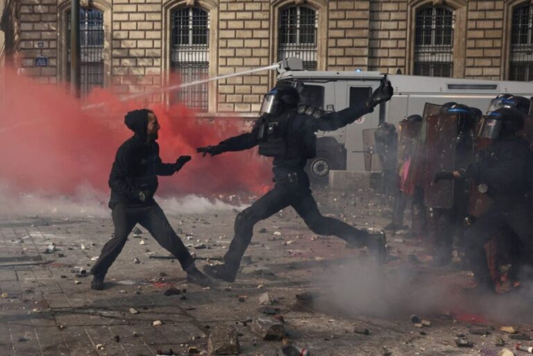 A protester faces off with French riot police amid clashes during a demonstration at the Place de la Republique in Paris on Saturday.