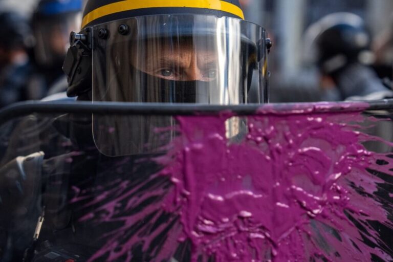 Paint thrown by protesters marks a police officer's shield during demonstrations in Paris on Saturday.