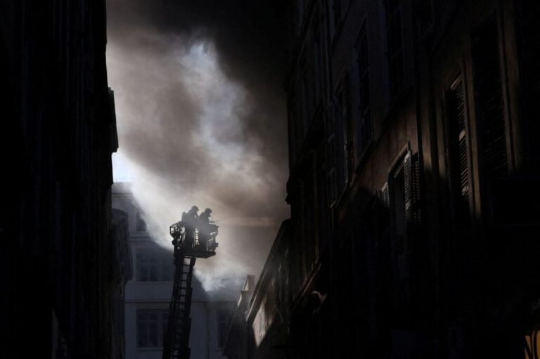 French firefighters work to extinguish a fire in a building amid clashes during a demonstration in Marseille on Saturday.