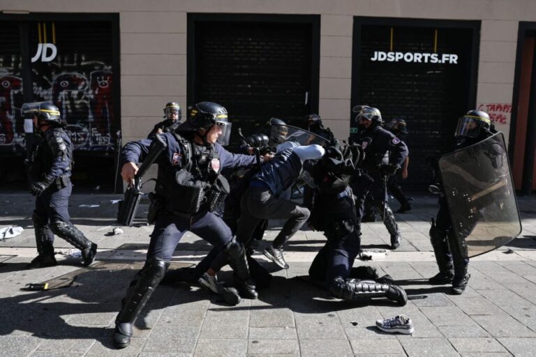 French security officials detain a protester during clashes prior to the start of a demonstration in Marseille on Saturday.