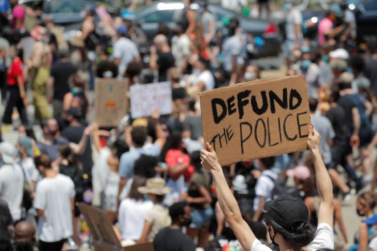 A demonstrator holds a sign reading