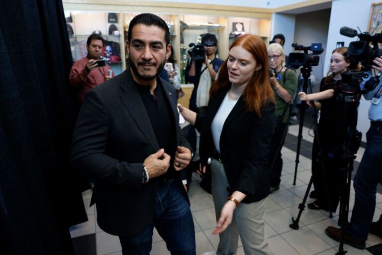 Abdul El-Sayed is escorted out by his spokesperson Roxie Richner, after speaking to the media at the Council of Carpenters & Millwrights facility in Warren, Michigan on October 3.