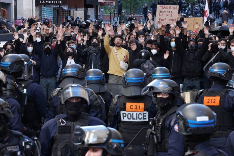 Masked protesters face off with French riot police during a demonstration in a street near the Gare du Nord train station in Paris on Saturday.