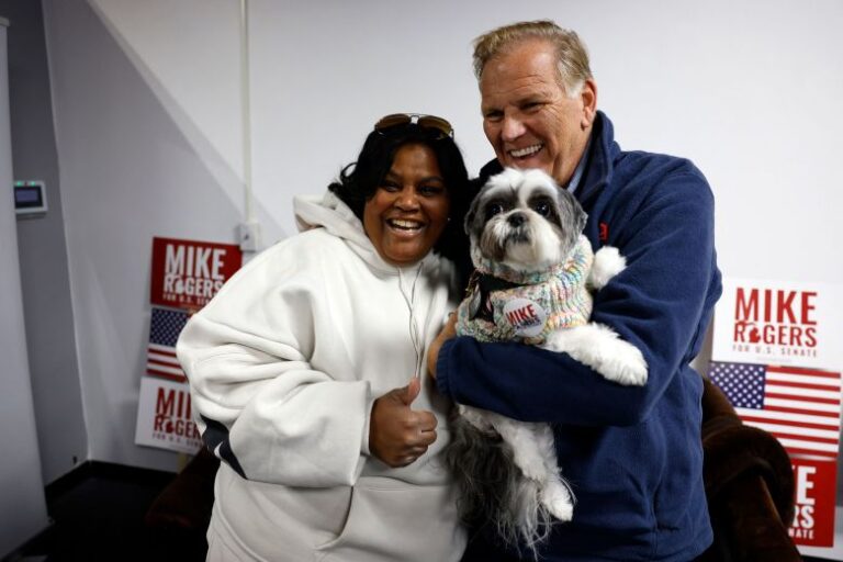 Rogers meets a supporter and her dog at his new campaign office in Detroit on Saturday.